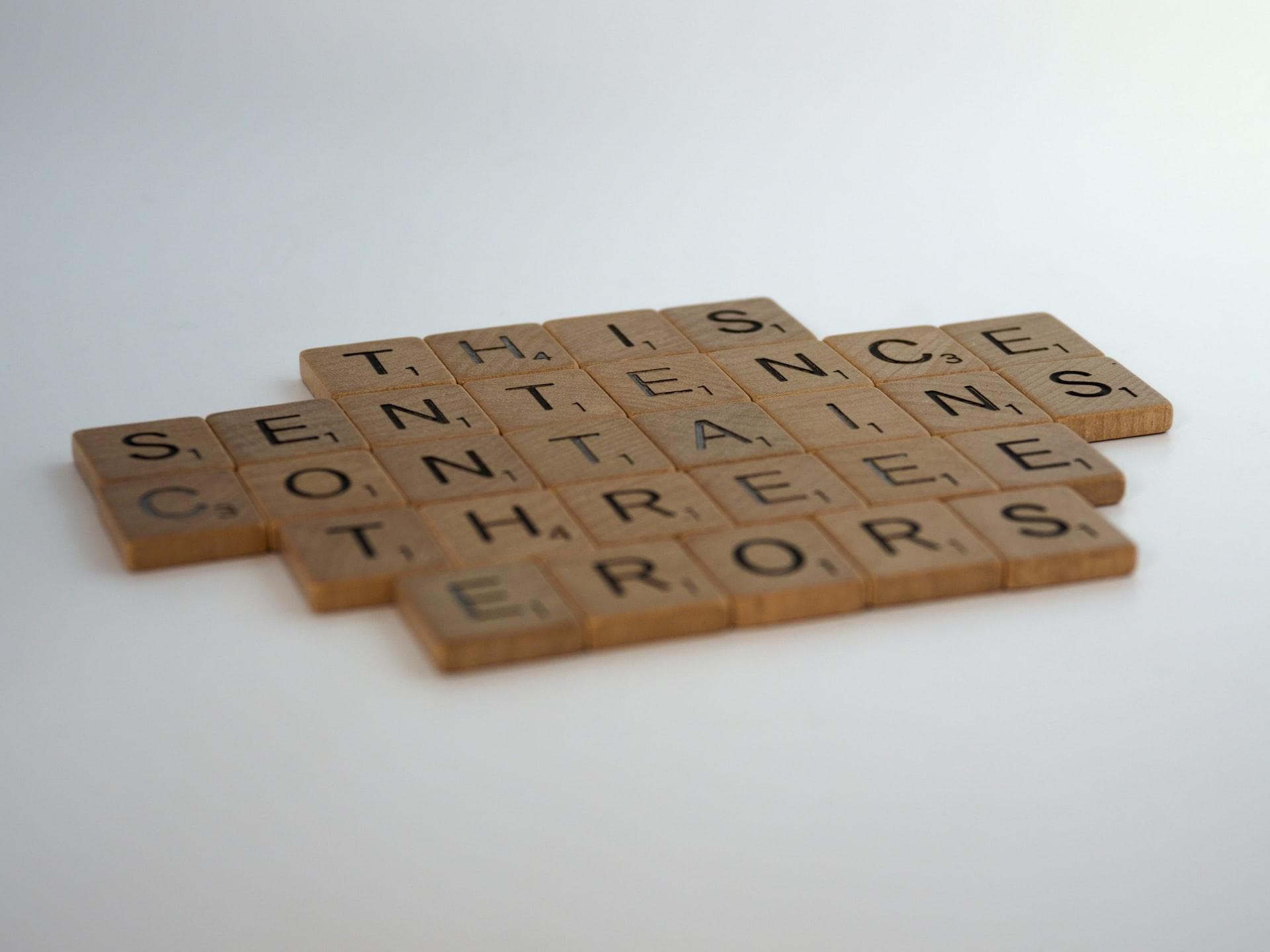 Scrabble pieces showing the sentence: "THIS SENTENCE CONTAINS THREEE ERORS"