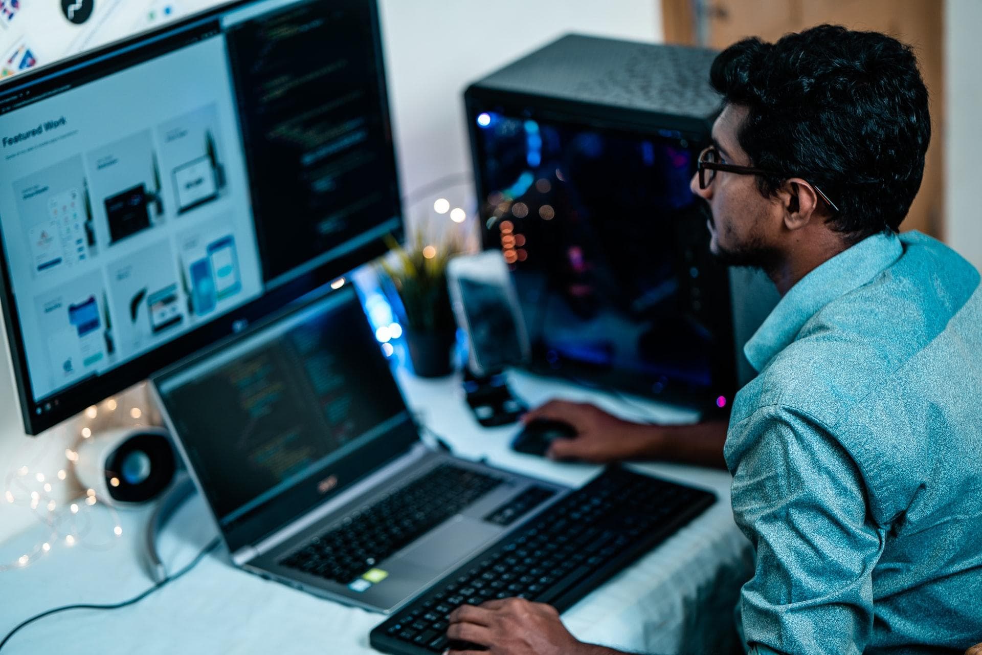 Person in front of computer setup, programming a website